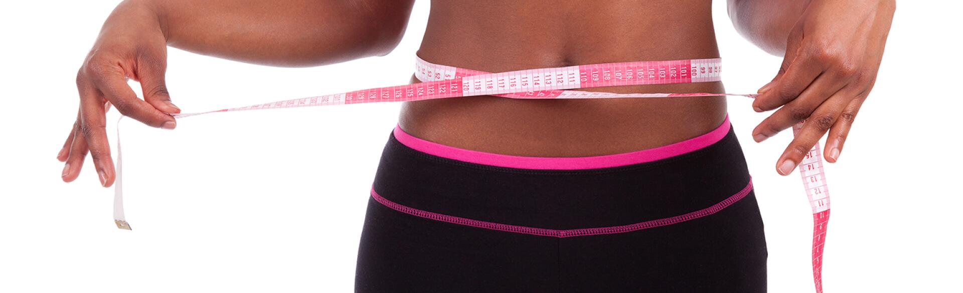 African American athlete with tape measure around stomach