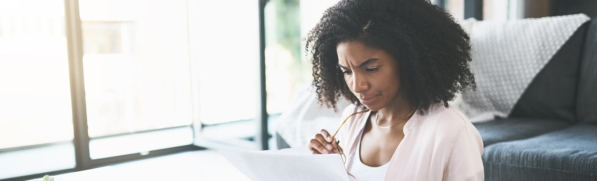 Woman sitting at table looking over finances