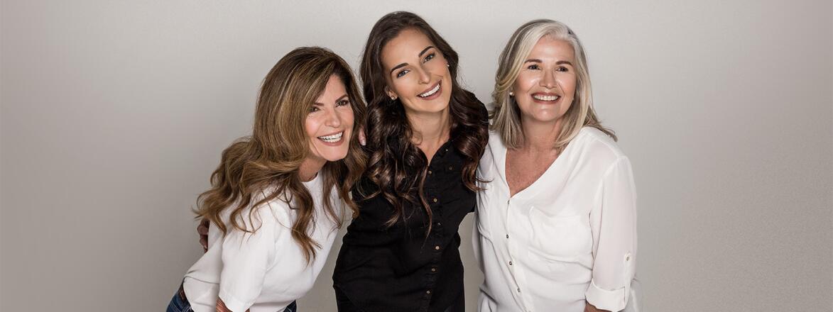 Three woman standing in front of a gray seamless