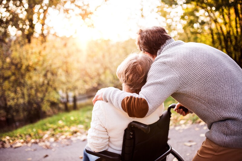 Senior couple in wheelchair in autumn nature.