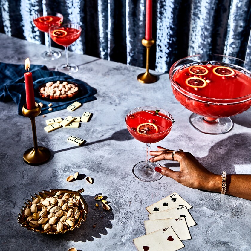 Hand reaching out to cranberry spiced rum punch cocktail