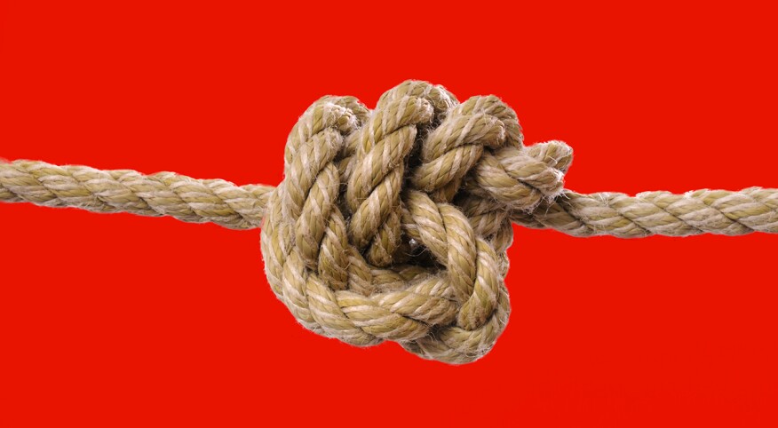 Knot in rope on red background