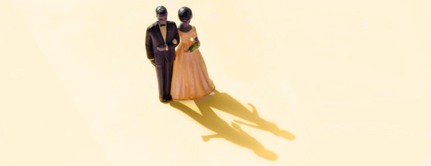 wedding cake topper of couple with shadow showing couple separate 