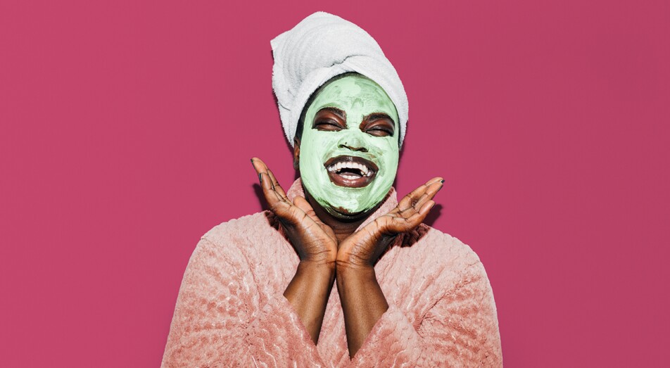 Black woman with facial mask smiling