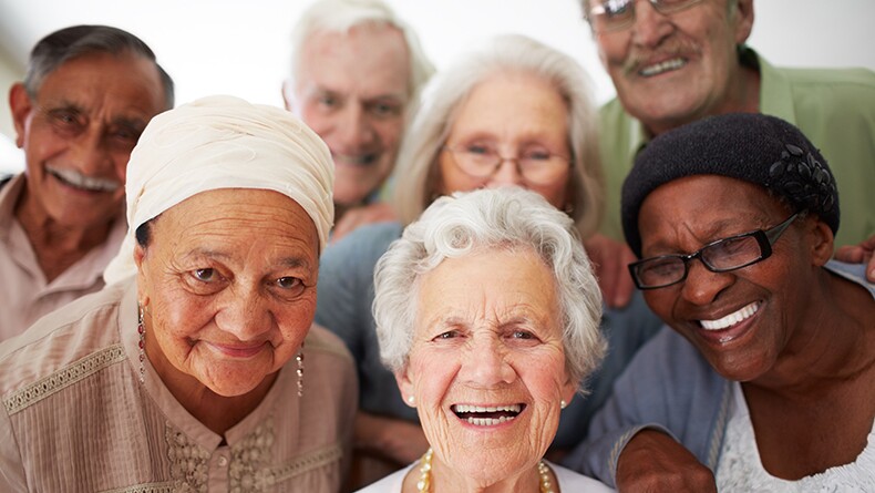 A group of diverse seniors smile 
