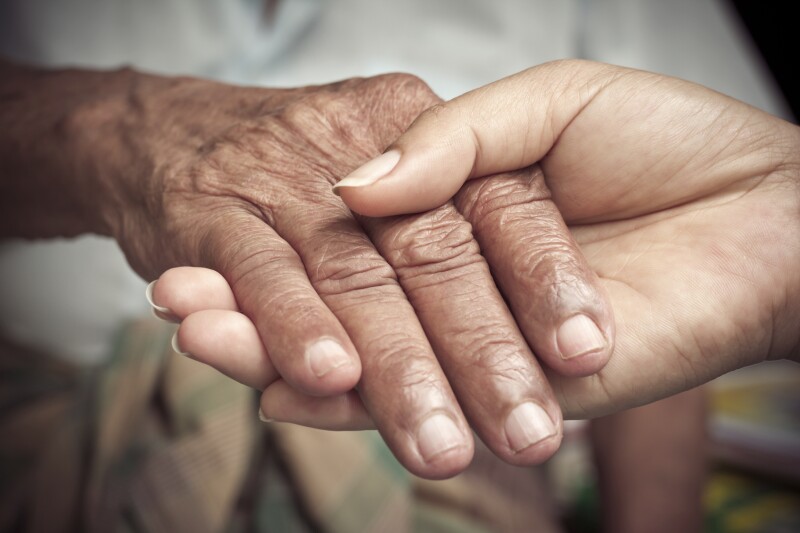 Senior and young holding hands