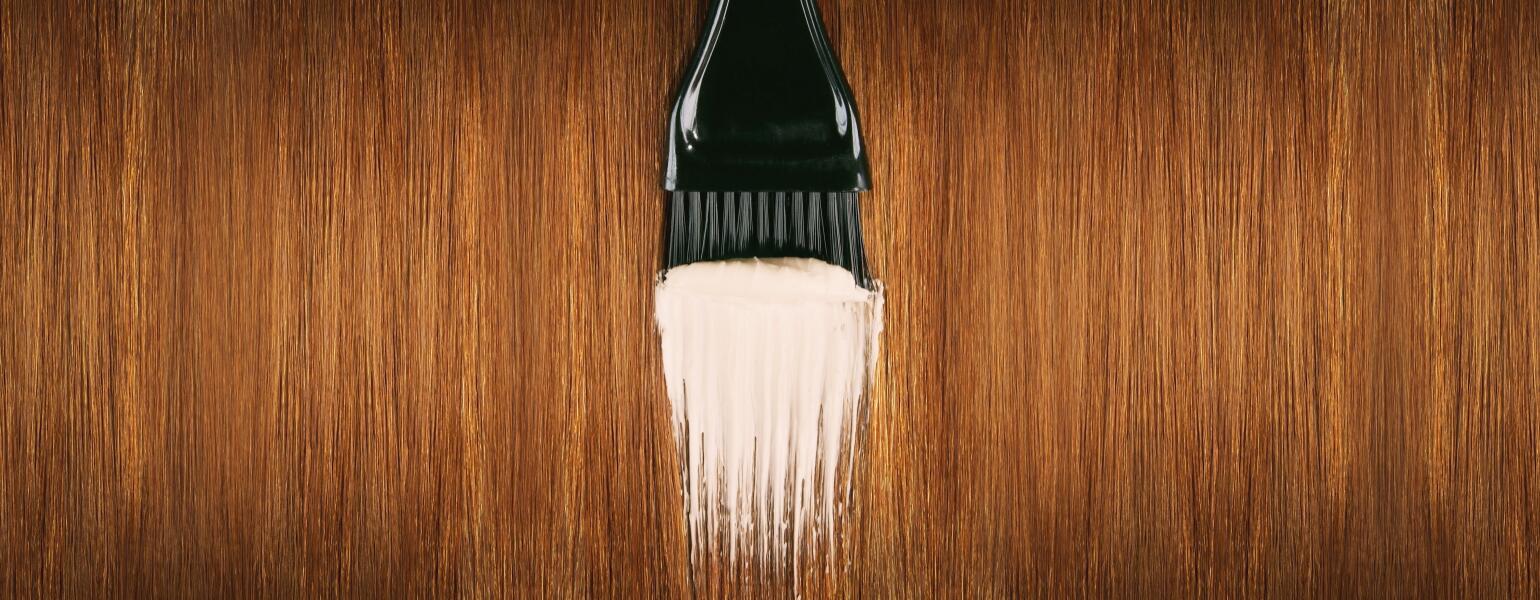 Red hair with brush applying hair dye