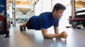Man holding plank position at gym