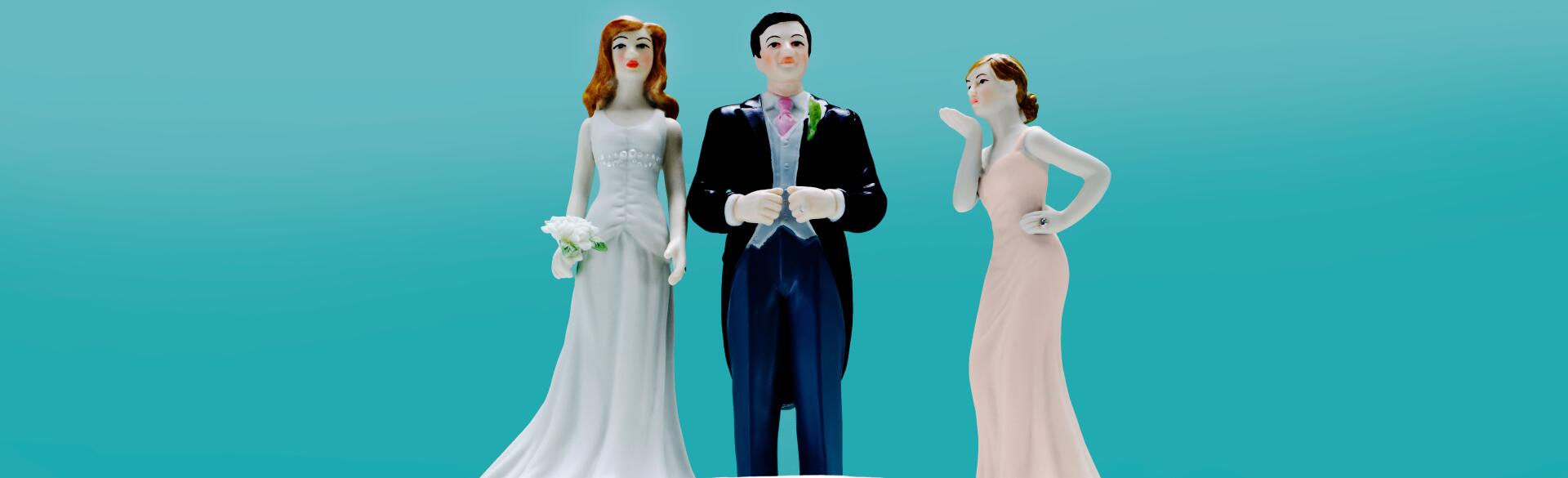 Wedding Cake with 3 toppers, a couple and a 2nd woman.