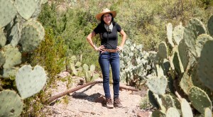 Woman hiking Mule Ears Spring trail at Big Bend National Park, standing between cacti