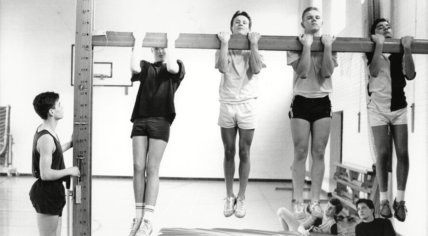 Teenage boys performing fitness test in gym class