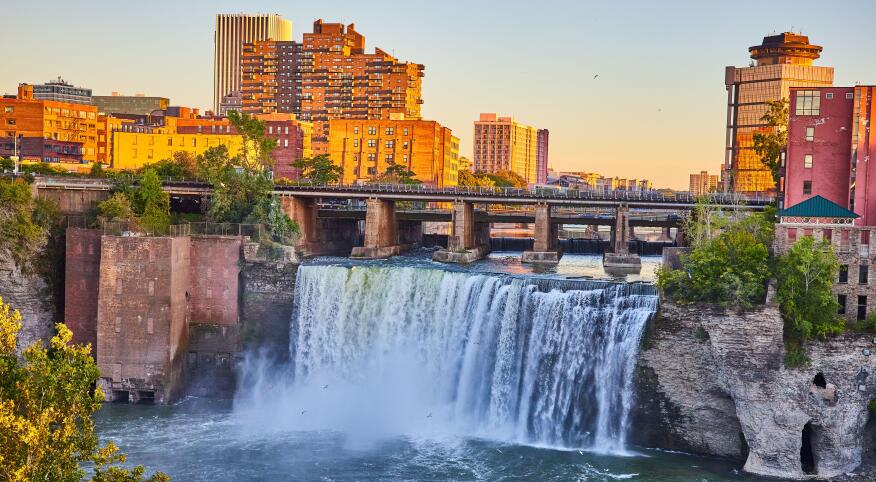 Rochester New York stunning natural waterfall next to downtown skyline at sunset