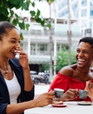 3 women having a laugh outside at a coffee shop