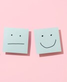 Three blue sticky notes with faces on pink background