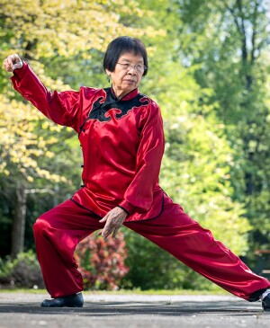 Tai Chi instructor doing moves in red, satin outfit