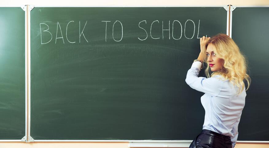 Sexy teacher standing near the blackboard