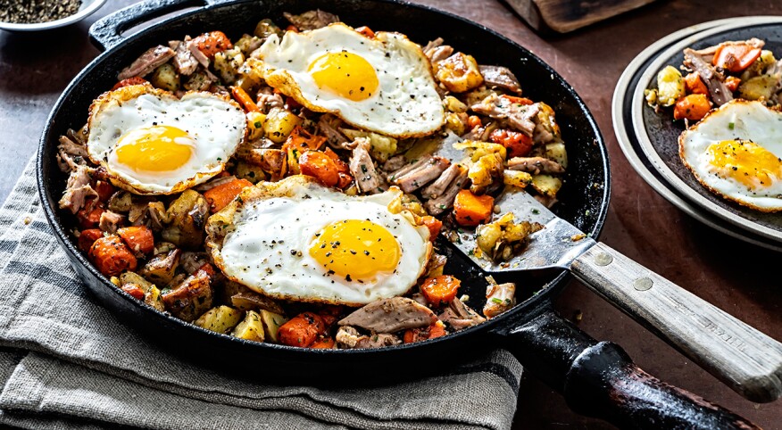 Turkey breakfast skillet with fried eggs in cast iron pan