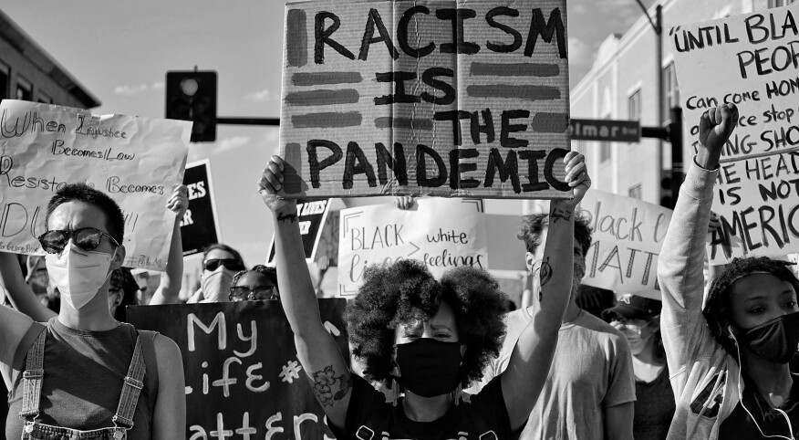 image_of_people_with_masks_protesting_and_holding_signs_h_15386991_1800