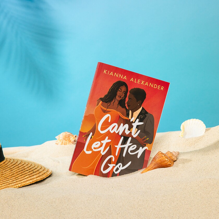 Book styled in pile of sand with beach accessories