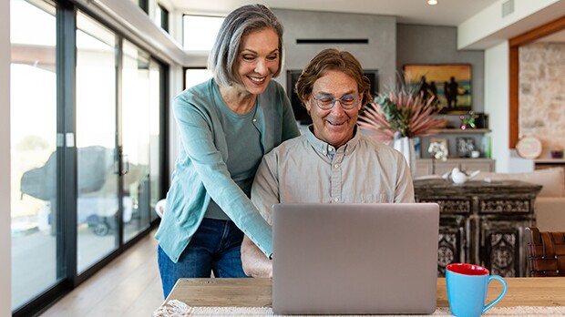 Two Feedback Forum participants, a man and a woman, smiling at their computer