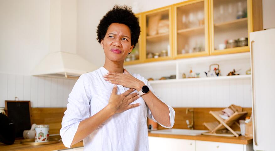 Distressed woman with acid reflux in her kitchen