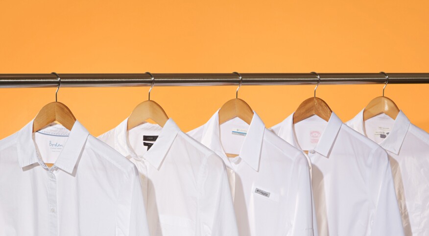 image of five white shirts on hangers