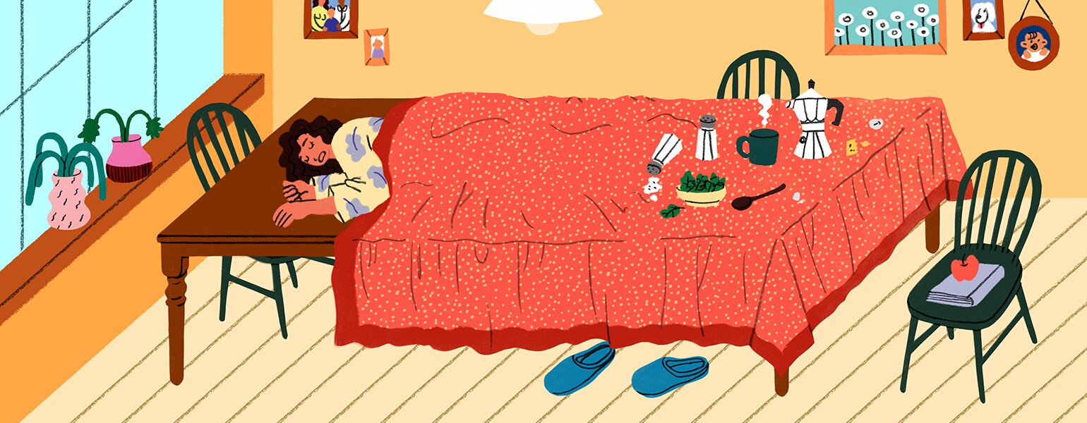 An extremely fatigued woman sleeps on her dining room table under a tablecloth.