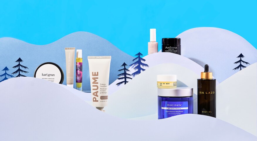 Beauty skincare products styled within cut paper winter scene