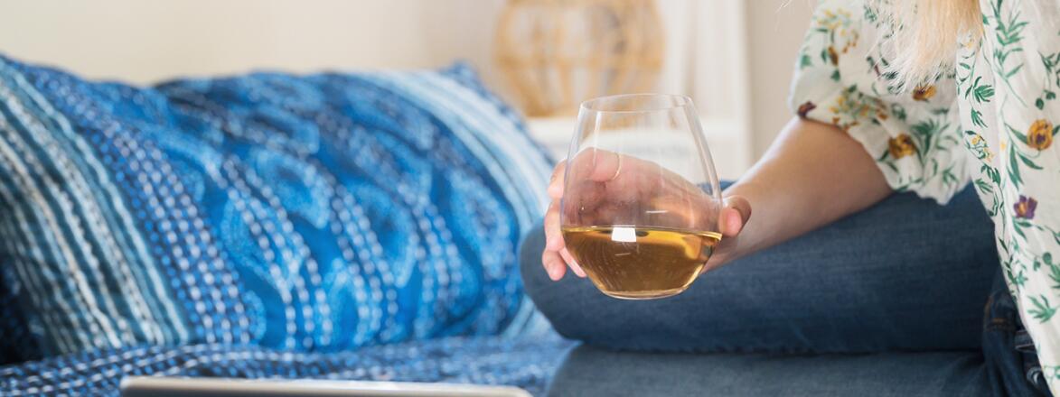 Woman With Glass Of Wine Using Tablet To Chat