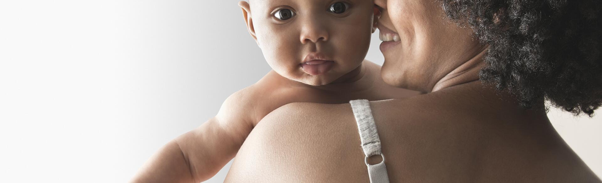 A woman holds her baby after a breast feeding session.