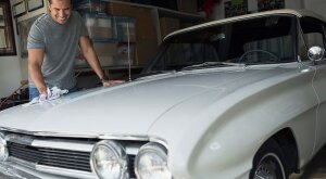 Man polishing white classic car