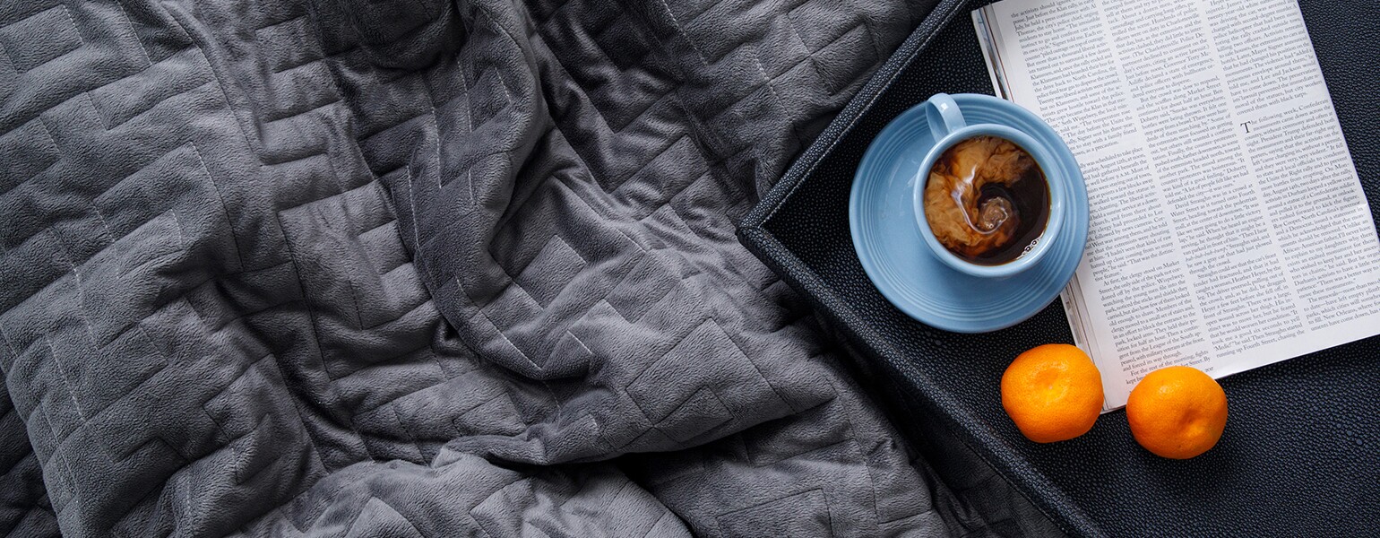 Weighted blanket on bed to help with anxiety and insomnia.