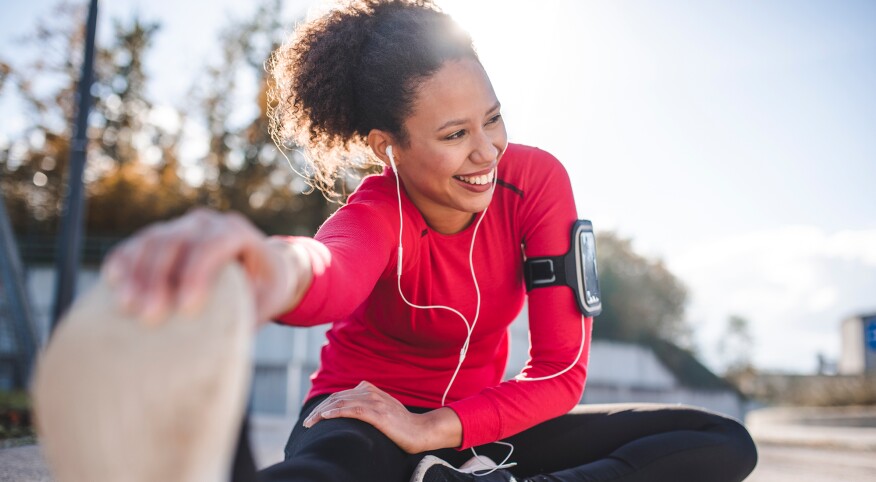 Woman stretching after a workout listening to her smartphone