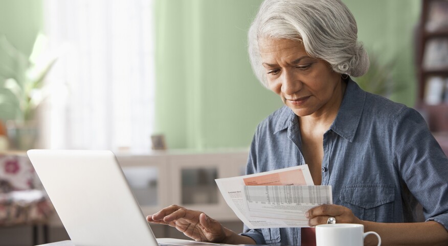 image_of_woman_looking_at_bills_and_laptop_GettyImages-182657424_v2_1800