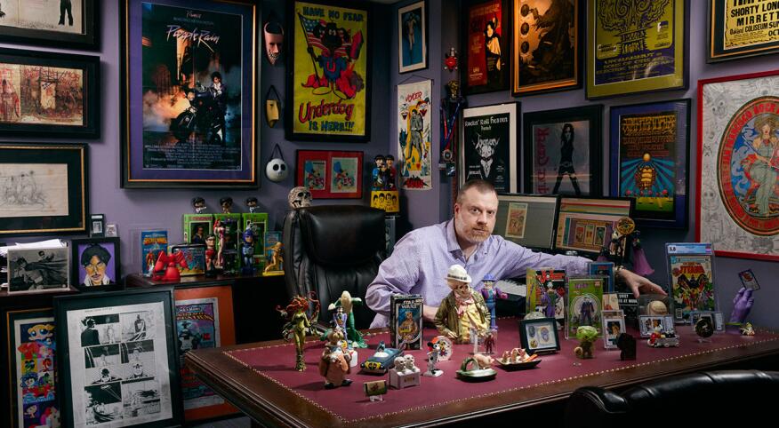 Alex Winter poses with his action figure and comic book collectibles