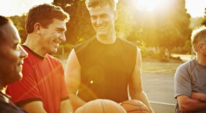 Group of men playing basketball with sunset