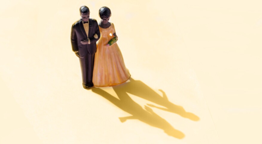wedding cake topper of couple with shadow showing couple separate
