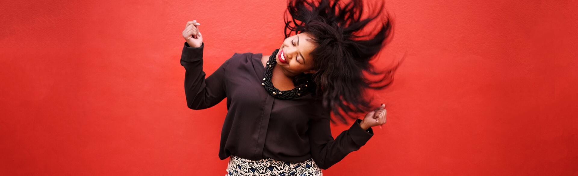 African American Woman Dancing on red background to cheer up