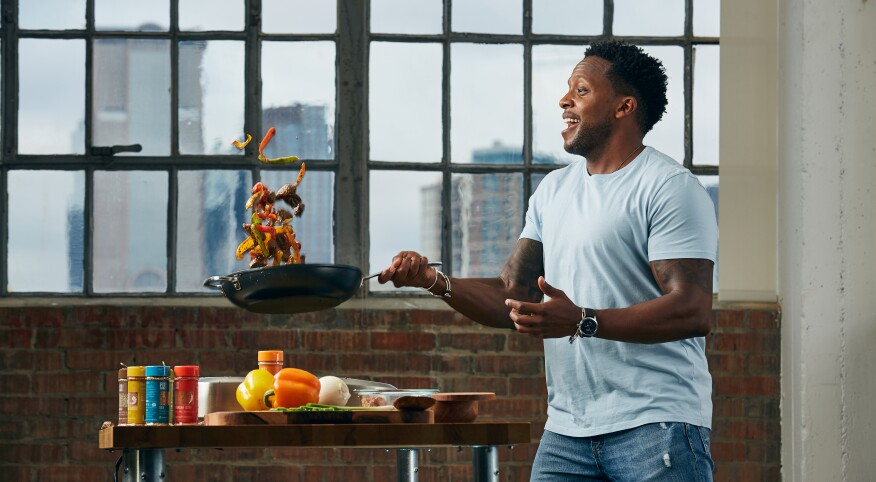 man flipping veggies in a pan