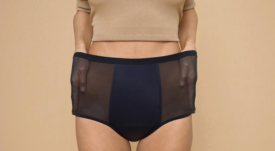 A woman stretches out the sides of her Thinx hi-waist panties, which can double for bladder leakage.