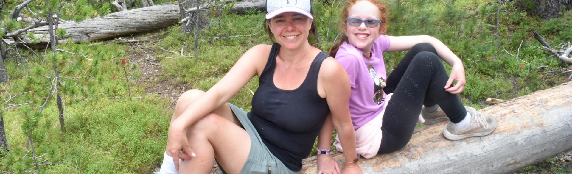 photo of author and her daughter outside hiking sitting on a log