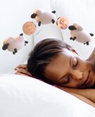 Photo of woman sleeping with sheep and coins over her head