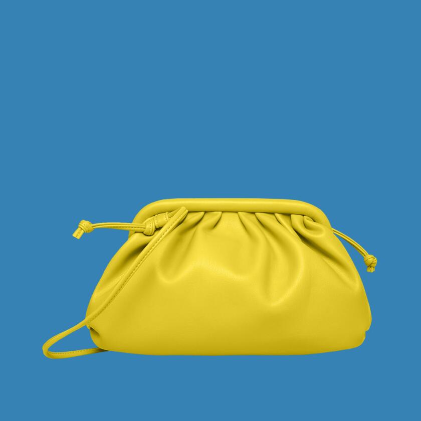Small yellow clutch purse on white background