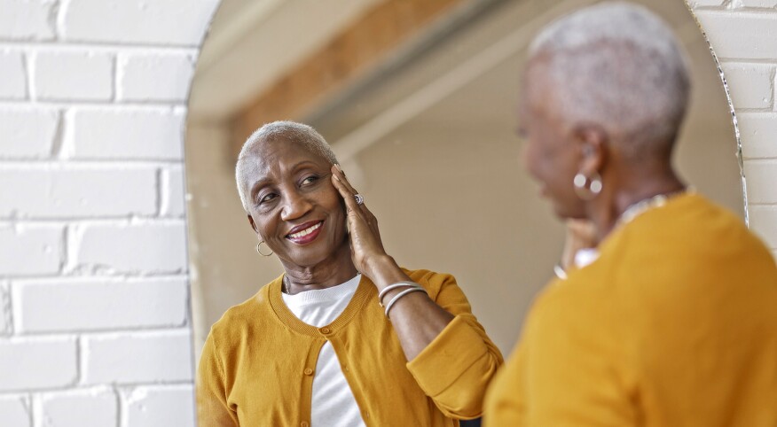 image_of_older_woman_looking_in_mirror_GettyImages-1340809252_1800