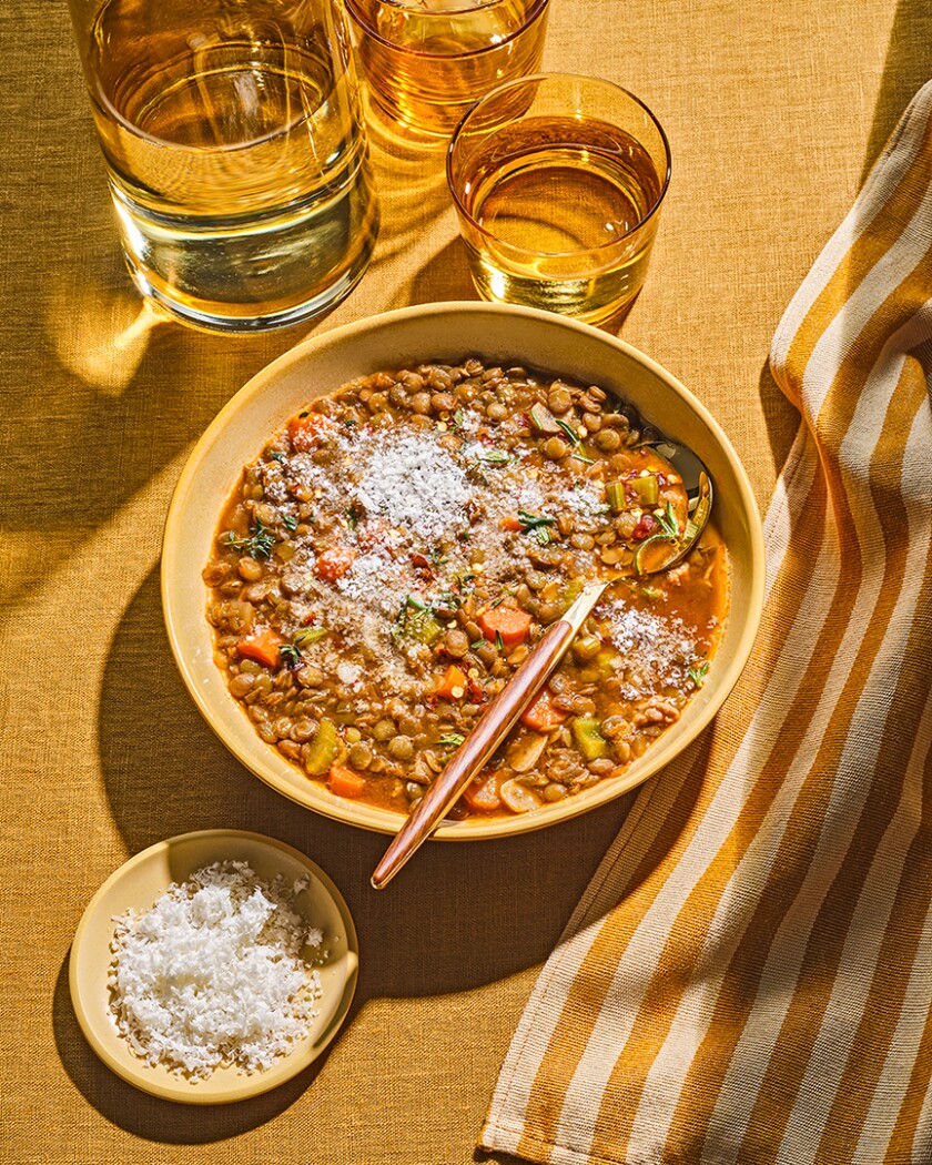 Overhead photo of Reese Witherspoon’s Lentil Slow Cooker Soup in yellow bowls and props