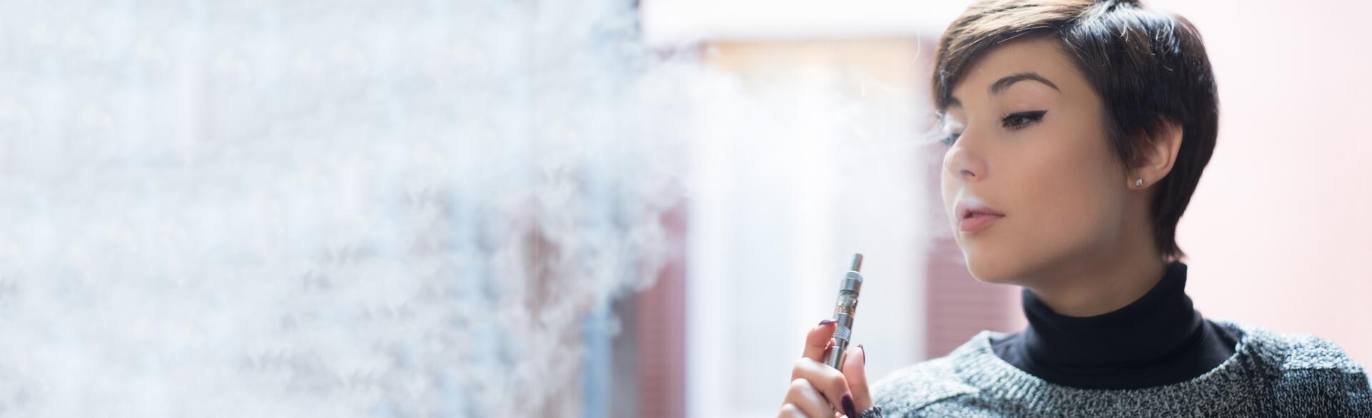 close up of a young woman smoking a vape pen