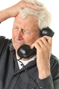 Older man on phone with scam artist