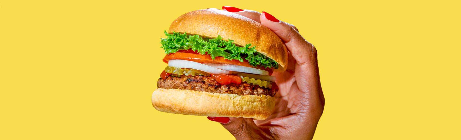 African American woman's hand holding a delicious looking burger