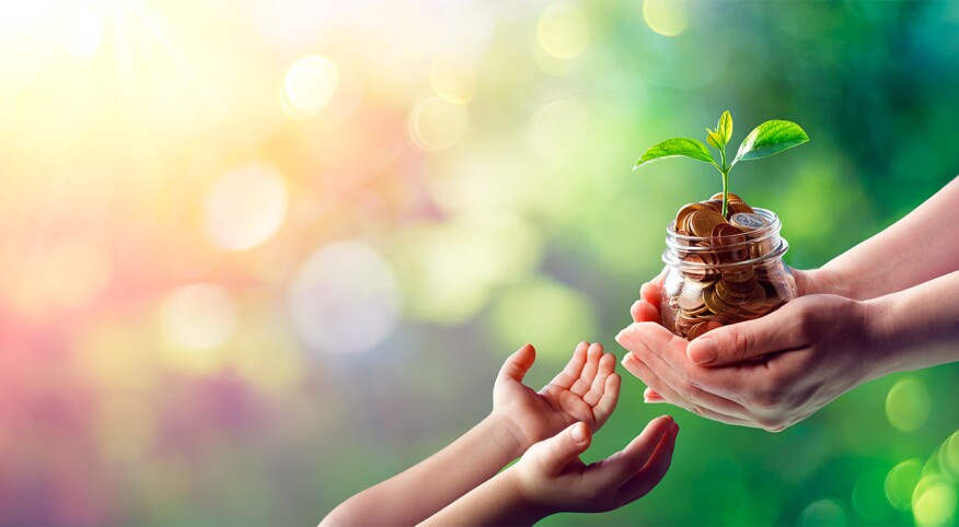 Image of person handing jar of coins to child