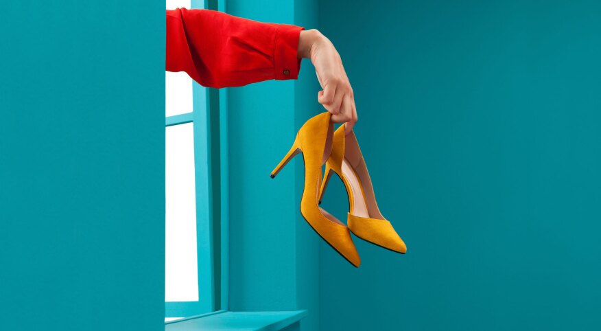 Woman throwing yellow high heels out a window